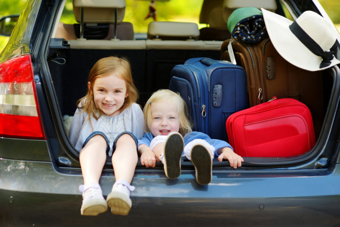 Two adorable little sisters sitting in a car