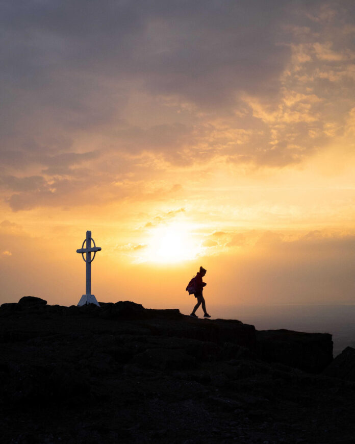 A shot of a hiker by the famous cross atop Galtymore. (Pic: Tommie McDonnell)
